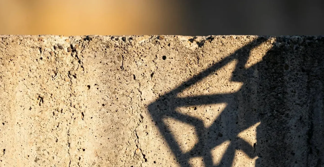 Jeu d'ombres et de lumière créant des formes ambiguës sur une surface texturée